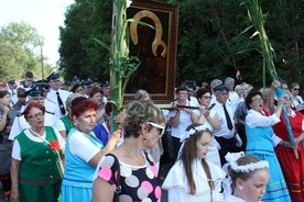 Członkinie Zespołu Tańca Ludowego "Lipowiacy" niosą przed obrazem Matki Bożej łuk upleciony z zielonych pędów roślin