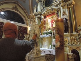 Wierni w osobistej modlitwie przed figurą św. Michała Archanioła