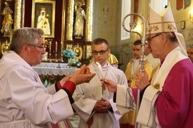 Bp Piotr Libera zapala "kaganek wiary" na rozpoczęcie doby nawiedzenia. W tle odnowiony ołtarz główny czernickiego kościoła