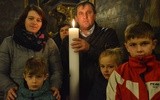 Rodzina ze świecą jubileuszową 1050. rocznicy chrztu Polski