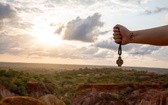 "Foska", znak Ruchu Światło-Życie na tle zachodzącego słońca nad kanionem Kilifi, Kenia